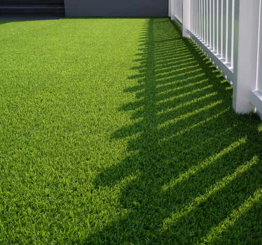 groen-kunstgras-naast-een-wit-hek